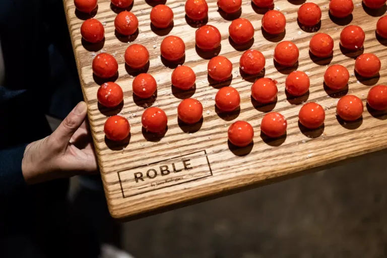 Aperitivos con forma esférica roja sobre una tabla de madera